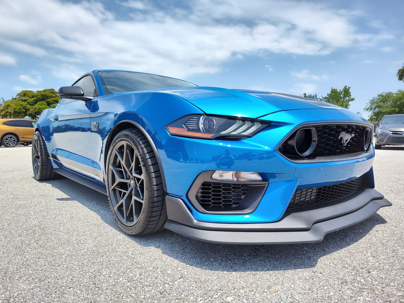 Low front three-quarter of a glossy blue Ford Mustang Mach 1.